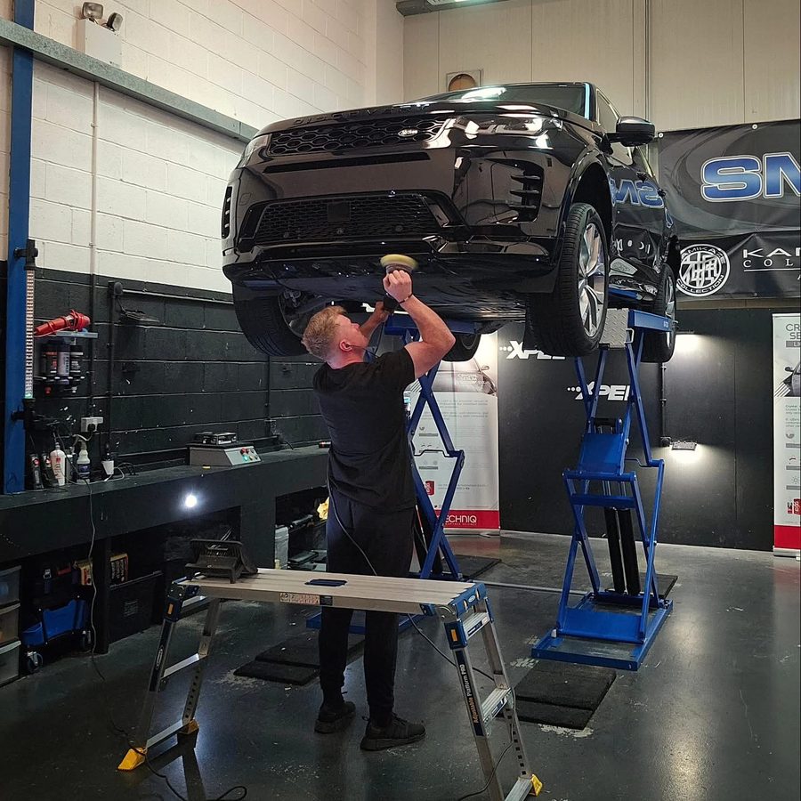 Working underneath a Land Rover Discovery raised on the full height ramp at SMC Detailing